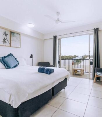 FRB_PrivateRoom Private room with a large bed, ceiling fan and glass doors opening onto a balcony